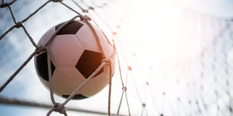 Bola de futebol entrando no gol representando oportunidades de carreira no futebol fora das quatro linhas