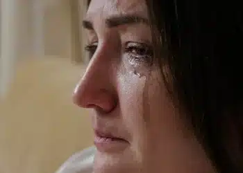 Mulher com lágrimas escorrendo pelo rosto, refletindo emoções intensas e choro repentino