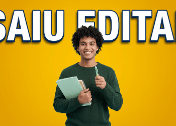 Jovem negro sorridente com cabelo crespo segura cadernos verde-menta e caneta verde, fundo amarelo vibrante com texto SAIU EDITAL