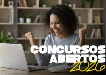 Mulher negra de cabelos cacheados sorri e comemora com os braços levantados em frente a um notebook aberto, com os textos "Concursos Abertos 2026" sobrepostos em branco e amarelo, representando candidatos que podem se inscrever no concurso público da Prefeitura Municipal de Guzolândia — SP, com vagas para Escriturário, Nutricionista Clínico, Médico Pediatra e outros cargos em 2026