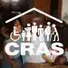 Família reunida na sala de casa com logotipo do CRAS em destaque, representando o papel do Centro de Referência de Assistência Social no atendimento a pessoas em situação de vulnerabilidade e as oportunidades de concurso público em 2026