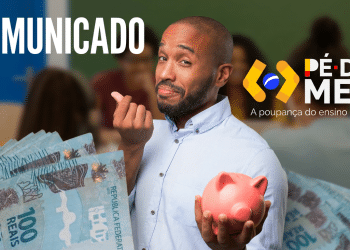 Jovem segurando cofrinho e notas de R$ 100 com logo do programa em sala de aula