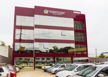 Fachada do campus da Universidade Federal de Santa Catarina em Blumenau, com estacionamento frontal e identificação institucional no topo do prédio