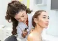 Dermatologista examinando a pele de uma paciente com dermatoscópio durante avaliação clínica.