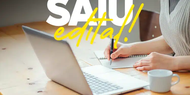 Pessoa anotando informações em caderno ao lado de notebook, em referência aos editais publicados pelo ICMBio em 2026