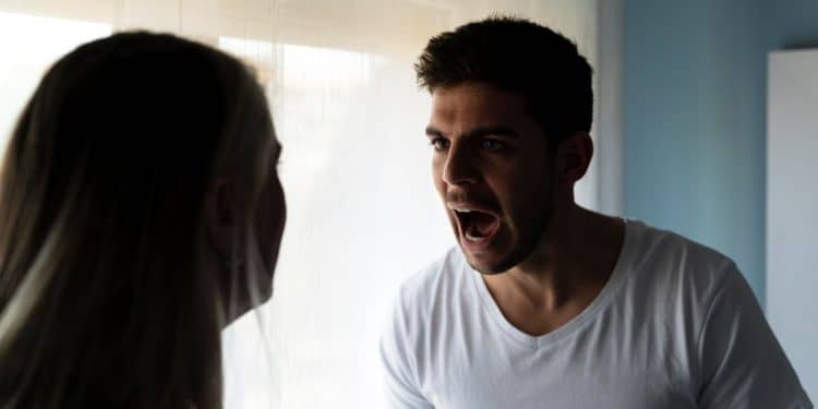 Homem gritando para mulher durante discussão em ambiente doméstico, refletindo um comportamento tóxico.