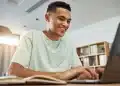 Jovem utilizando notebook representando as inscrições online para os cursos gratuitos de capacitação profissional.