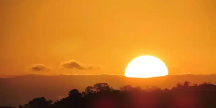 pôr do sol quente, simbolizando os dias de verão, com a dúvida sobre o retorno do horário de verão em 2026.