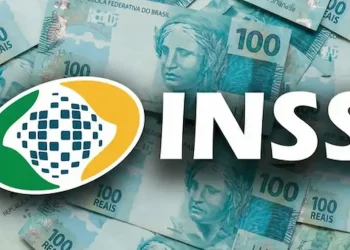 Logo do INSS sobre notas de 100 reais, relacionado ao pagamento do benefício de R$ 2.431,50 em 2026.