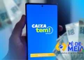 Tela do aplicativo CAIXA Tem em um smartphone, com a logo do serviço e cédulas de dinheiro ao fundo, relacionado ao processo de liberação de conta para estudantes menores de idade no programa Pé-de-Meia.