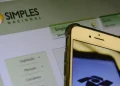 Tela com portal do Simples Nacional e celular com logo da Receita Federal representando as novas regras para microempresas