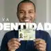 Homem sorrindo e segurando a nova Carteira de Identidade brasileira com o título 'Nova Identidade' ao fundo.