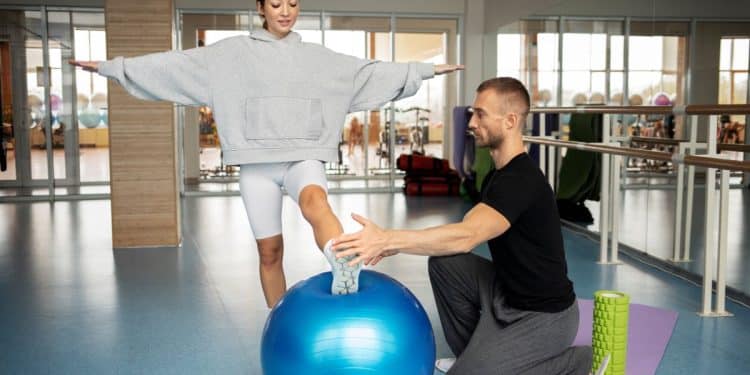 Profissional de Educação Física auxiliando paciente em processo de reabilitação física, destacando as diversas áreas de atuação na área.