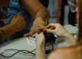 Atendente realiza coleta de biometria das digitais de cidadão em posto de atendimento, ilustrando o cadastro biométrico exigido para programas sociais até dezembro de 2026