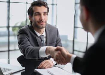 Profissional recém-contratado cumprimenta o gestor durante a integração na empresa.