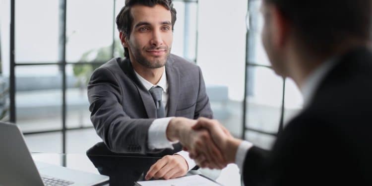 Profissional recém-contratado cumprimenta o gestor durante a integração na empresa.