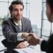 Profissional recém-contratado cumprimenta o gestor durante a integração na empresa.