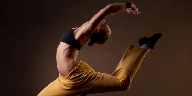 Dançarina executa salto artístico com flexibilidade e força, representando a valorização profissional após regulamentação da profissão de dançarino
