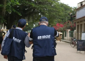Recenseadores do IBGE com colete azul em campo representando o concurso para recenseador 2026