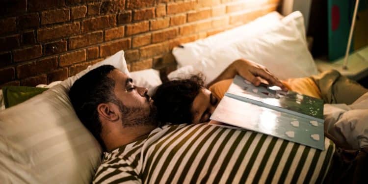 Casal adormecendo juntos na cama, ilustrando como o contato próximo pode induzir o sono devido à sensação de segurança e carinho.