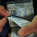 Mãos contando cédulas de R$ 100 do real, representando o saque liberado pela CAIXA aos trabalhadores beneficiados.