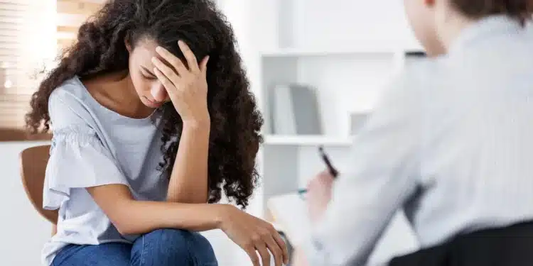 Profissional demonstrando sinais de estresse emocional durante atendimento psicológico no ambiente de trabalho