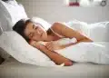 Mulher dormindo confortavelmente na cama representando a importância das horas ideais de sono por idade