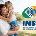 Mulher sorrindo ao segurar uma criança loira ao lado da logo do INSS.