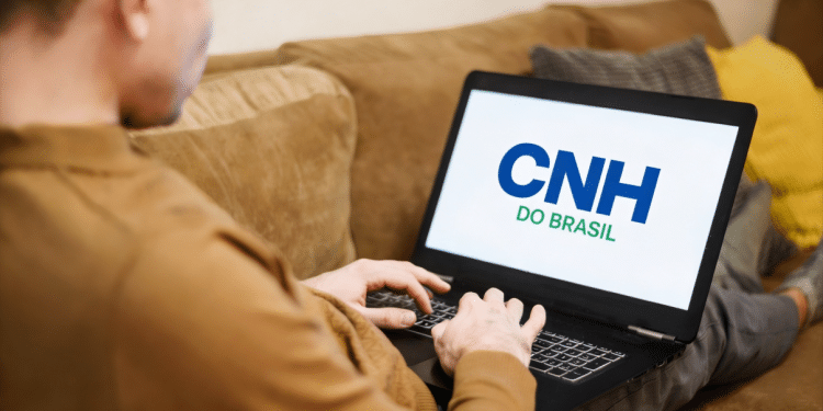 Homem olhando para a tela do notebook com o nome "CNH no Brasil".