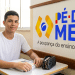 Jovem ao lado da logo do programa Pé-de-Meia.
