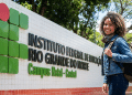 Estudante sorridente na entrada do IFRN Campus Natal-Central.
