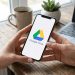 Google Drive em smartphone com laptop e café em ambiente doméstico.