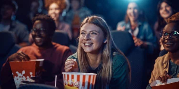 Jovens assistindo filme no cinema.