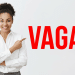 Profissional sorridente aponta para texto "VAGAS" em vermelho.