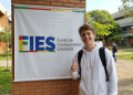 Estudante comemora aprovação no FIES em campus universitário.