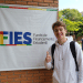 Estudante comemora aprovação no FIES em campus universitário.
