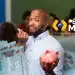 Estudante com expressão de dúvida segurando cofre rosa em sala de aula, ao lado do logotipo do Pé-de-Meia e cédulas de R$ 100, representação do bloqueio silencioso do benefício por cadastro irregular.