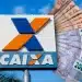 Placa com a logomarca da Caixa Econômica Federal ao lado de cédulas de R$ 50 e R$ 200 dispostas em leque, em referência ao Saque-Calamidade do FGTS de até R$ 6.220 liberado pelo banco, cujo pedido pode ser feito pelo aplicativo.