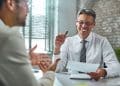 Recrutador conversa com candidato sobre competências para vaga de emprego.