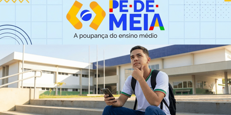 Estudante do ensino médio consulta o celular em frente a uma escola pública, com a logomarca do Pé-de-Meia