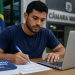 A Câmara Municipal de Tietê, em São Paulo, divulgou uma retificação do Concurso Público destinado a preencher 1 vaga para um profissional com curso superior completo em Direito, Gestão Pública, Administração, Ciências Contábeis ou Economia. Conforme a 1ª Retificação do edital, houve alteração no conteúdo programático de conhecimentos específicos. De acordo com o edital, a oportunidade é para o cargo de: Analista de Compras e Licitações (1 vaga) A jornada é de 30 horas semanais e a remuneração é de R$ 6.027,86. Os servidores também receberão auxílio-alimentação no valor de R$ 1.100,00, seguro de vida, plano de assistência médico-hospitalar e auxílio-transporte. As inscrições estão abertas de 27 de abril de 2026 a 26 de maio de 2026, até as 23h59, exclusivamente pelo site portal.cepasf.com.br. A taxa é de R$ 90,00. Candidatos inscritos no CadÚnico podem solicitar isenção da taxa de 27 de abril de 2026 a 2 de maio de 2026. A seleção será realizada por prova objetiva de múltipla escolha, com 50 questões, prevista para o dia 21 de junho de 2026, no período matutino. A contratação será pelo regime estatutário. O servidor cumprirá estágio probatório de 36 meses e estará sujeito ao Regime Geral da Previdência Social. Jovem de camiseta azul preenche formulário com caneta enquanto consulta laptop diante de edital de concurso público.