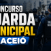 Guardas municipais fardados com uniforme azul-marinho e boné enfileirados em formação, com texto promocional do concurso