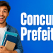 Jovem sorridente segura cadernos diante de fundo azul com texto "Concurso Prefeitura".
