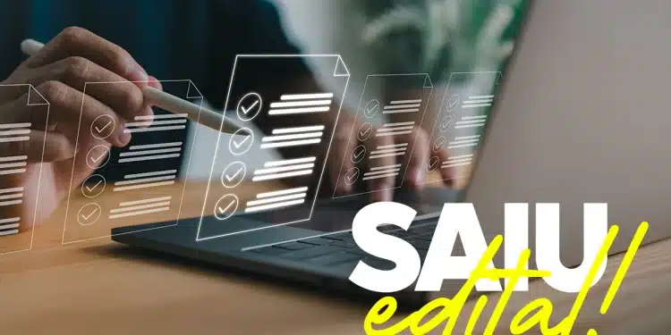 Mão segurando caneta stylus sobre laptop com ícones holográficos de checklist e texto "SAIU edital!" em destaque.