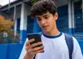 Estudante consultando no celular informações sobre os pagamentos do Pé-de-Meia liberados em maio