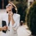 Mulher sorrindo enquanto fala ao celular em ambiente externo