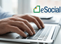Profissional utilizando notebook e logotipo do eSocial do lado.