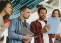 Grupo de jovens profissionais analisando documentos em ambiente de trabalho moderno e colaborativo