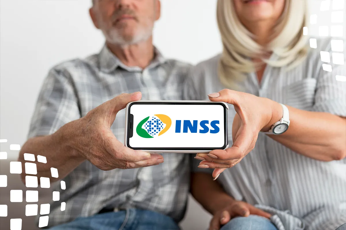 Casal idoso segura um celular com a logomarca do INSS e, ao redor, uma parede clara com formas luminosas