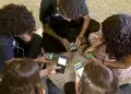 Grupo de adolescentes sentados em roda mexe em celulares, cena que ilustra o público afetado pela nova classificação indicativa do YouTube